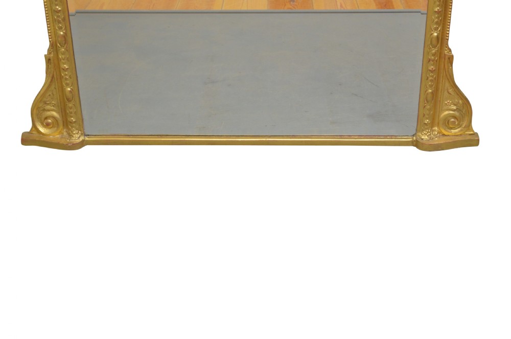 An ornate antique giltwood mantel mirror featuring a carved cherub crest and classical detailing. View VI