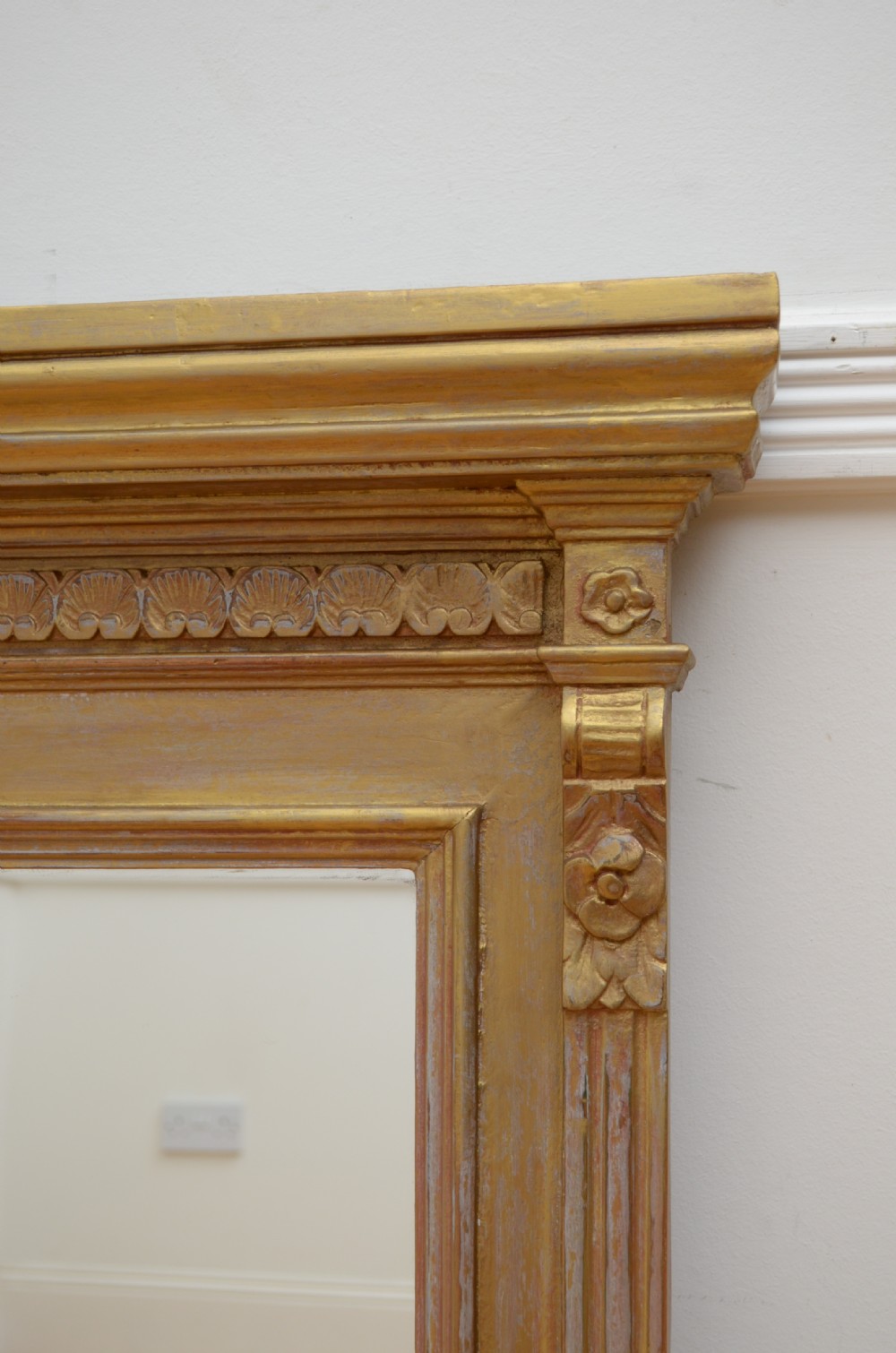 An upright Edwardian wall mirror featuring a carved wooden frame with gilt finish and decorative fluted pilasters. View VIII
