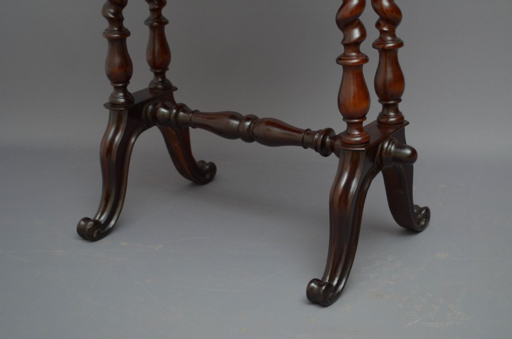 A Victorian rosewood work table featuring a hinged top surface, a keyhole drawer, a lower wooden work basket, four barley twist support legs, and scroll feet. View XIII