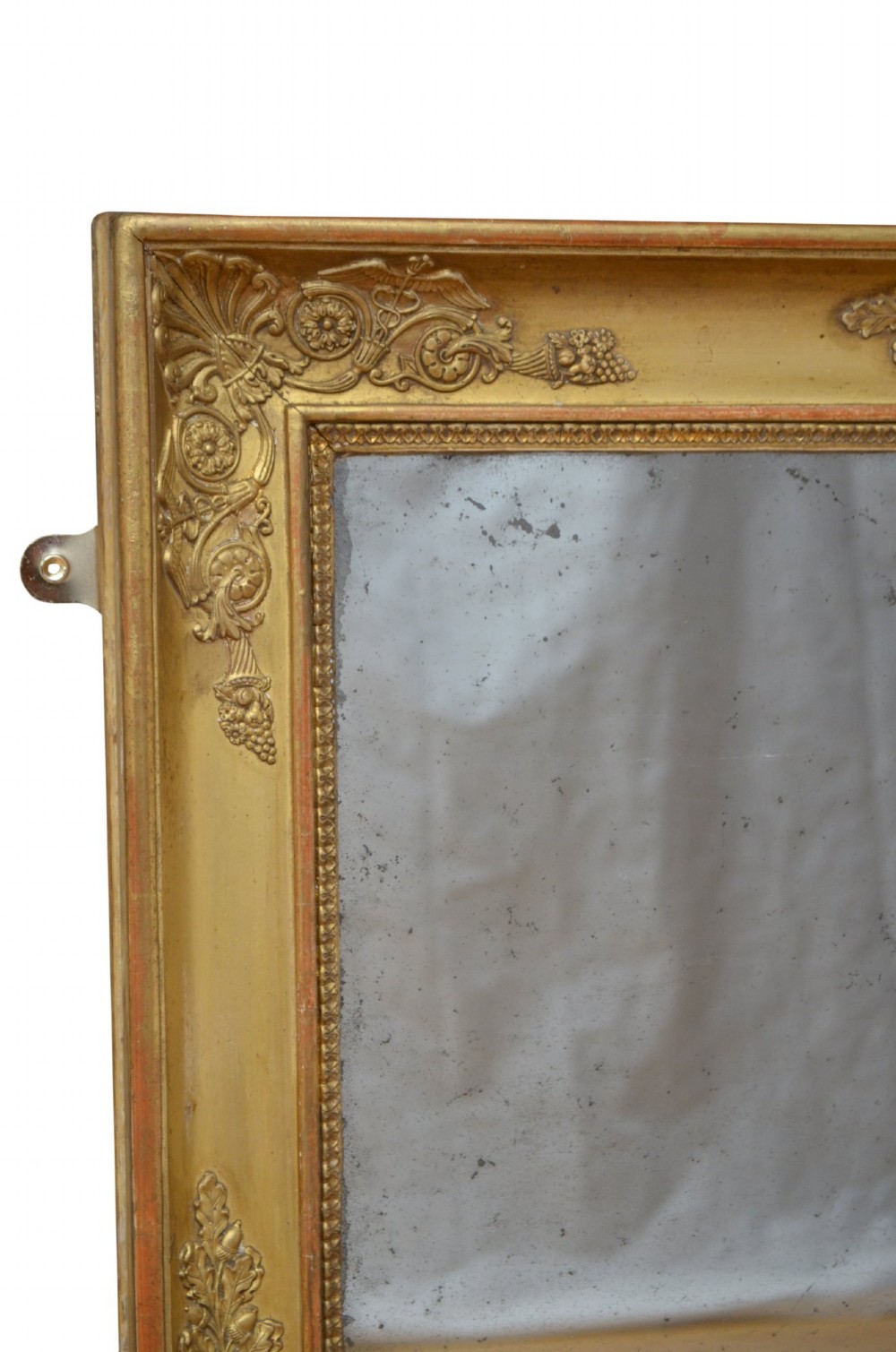 A rectangular Napoleonic giltwood wall mirror featuring detailed foliate low-relief carvings along the gilded frame. View IV