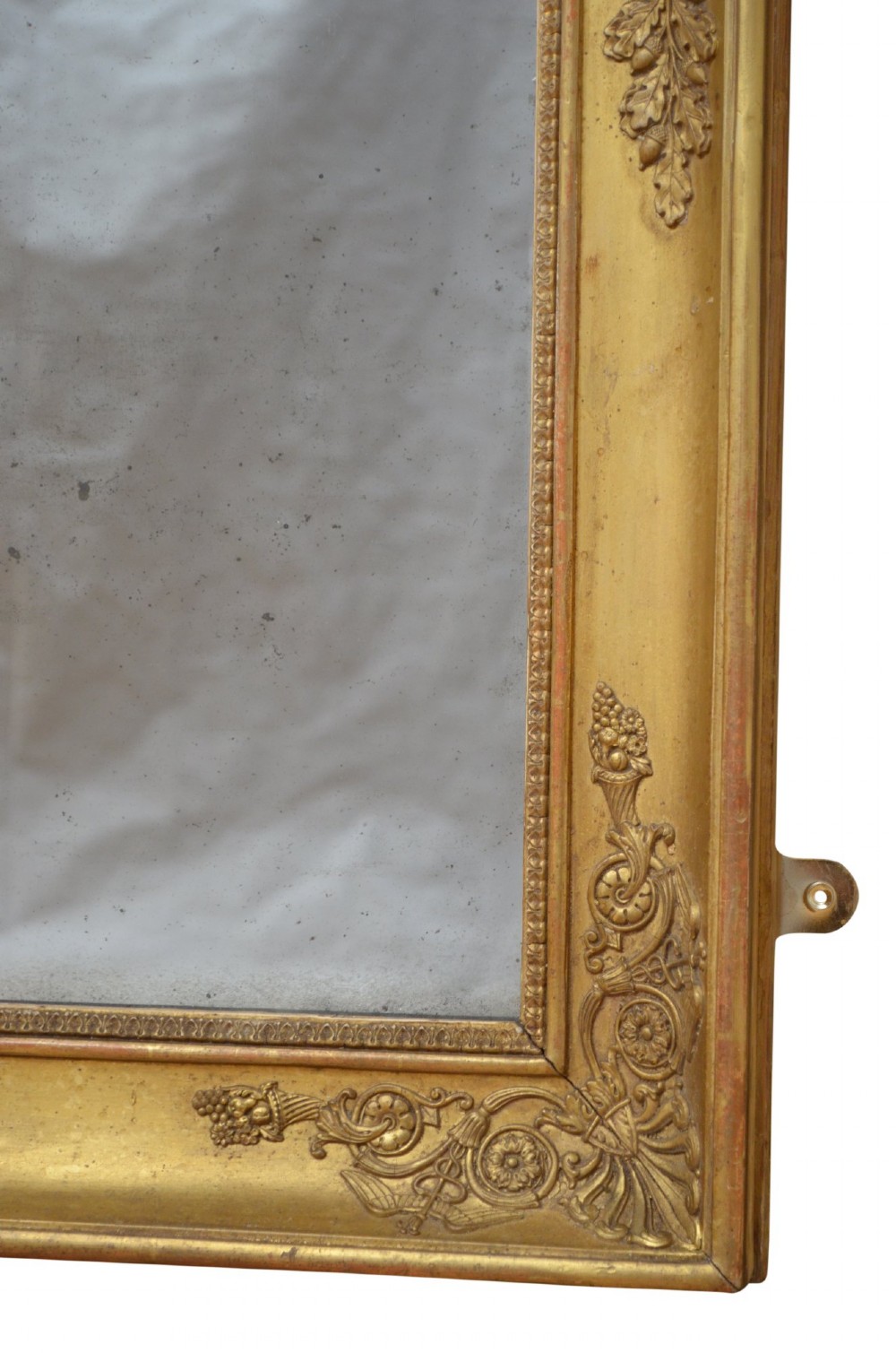 A rectangular Napoleonic giltwood wall mirror featuring detailed foliate low-relief carvings along the gilded frame. View VII