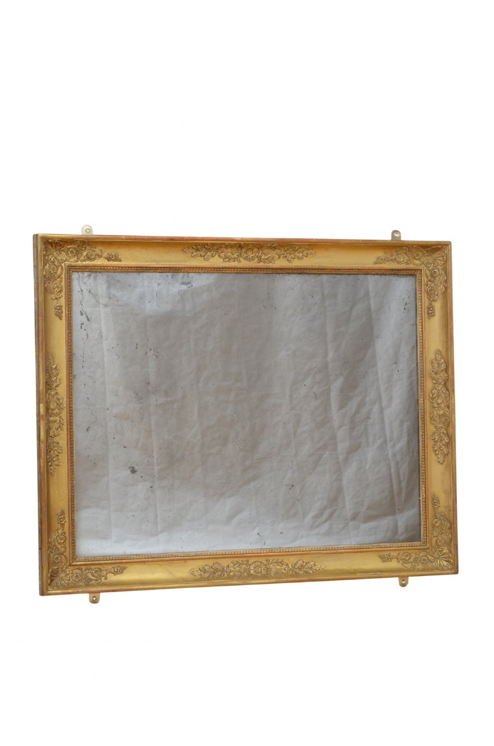 A rectangular Napoleonic giltwood wall mirror featuring detailed foliate low-relief carvings along the gilded frame. View IX