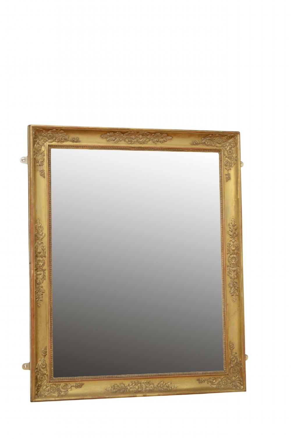 A rectangular Napoleonic giltwood wall mirror featuring detailed foliate low-relief carvings along the gilded frame.