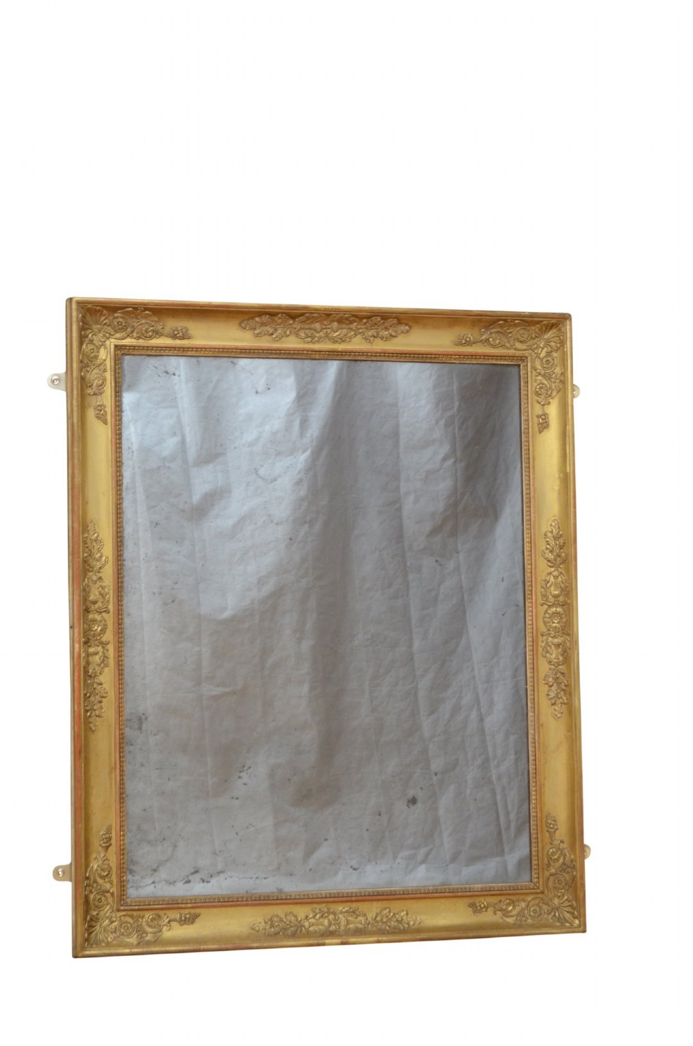 A rectangular Napoleonic giltwood wall mirror featuring detailed foliate low-relief carvings along the gilded frame. View X
