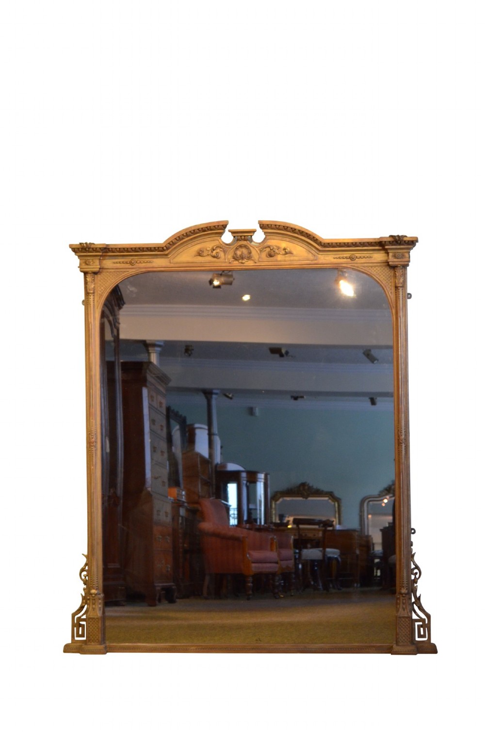 A large rectangular giltwood overmantel mirror featuring an arched top frame, carved cresting, side pilasters, and a gold finish. View V