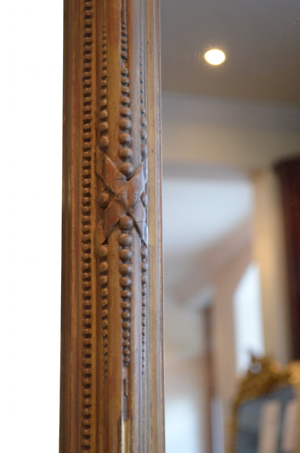 A large rectangular giltwood overmantel mirror featuring an arched top frame, carved cresting, side pilasters, and a gold finish. View VIII