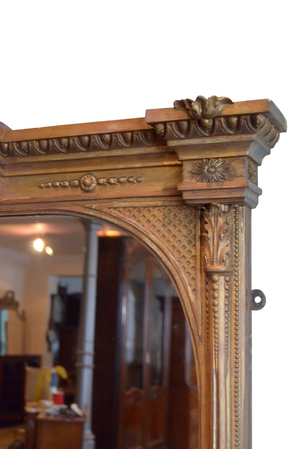 A large rectangular giltwood overmantel mirror featuring an arched top frame, carved cresting, side pilasters, and a gold finish. View XI