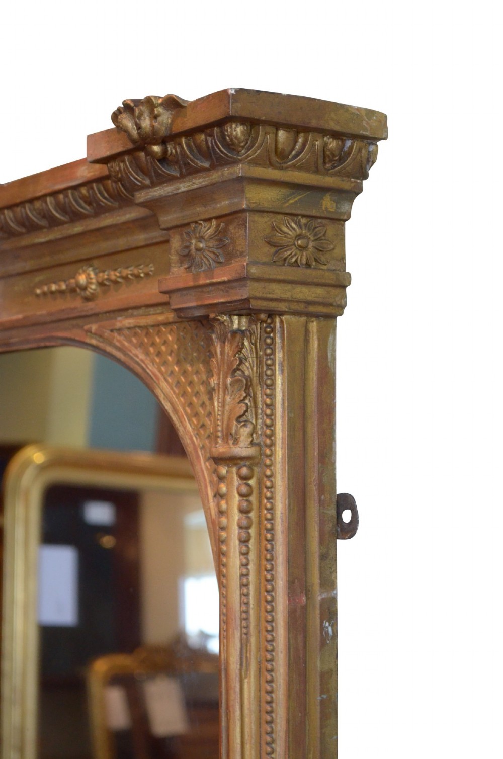 A large rectangular giltwood overmantel mirror featuring an arched top frame, carved cresting, side pilasters, and a gold finish. View XII