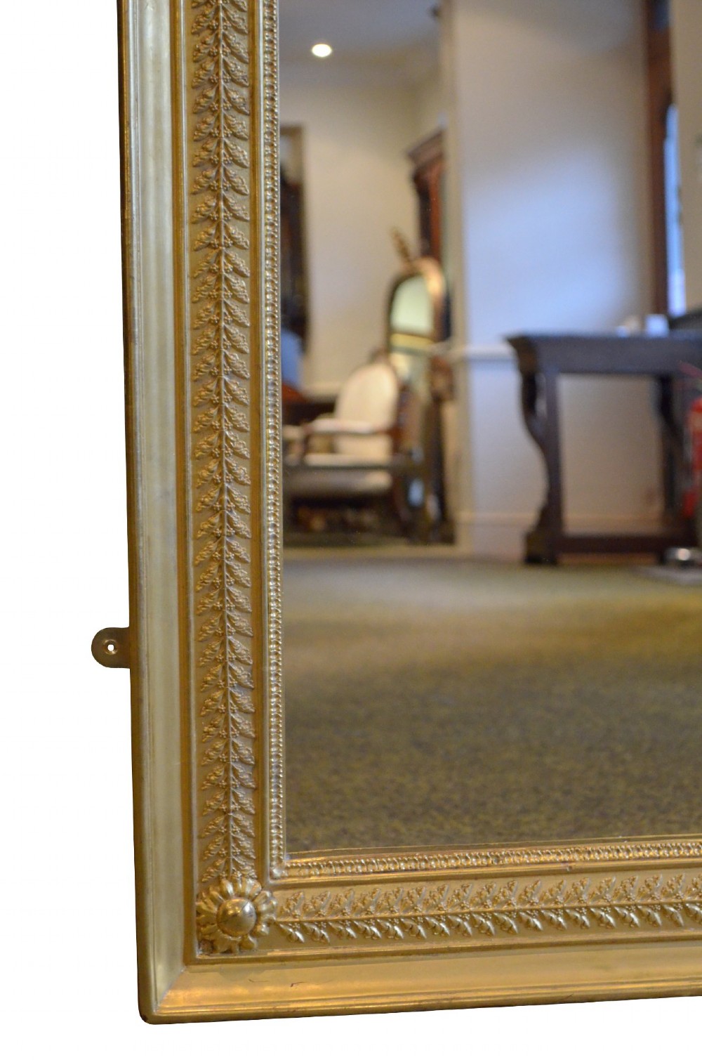 A large rectangular antique wall mirror featuring a carved giltwood frame decorated with detailed classical bead moulding and rosette bosses. View VI