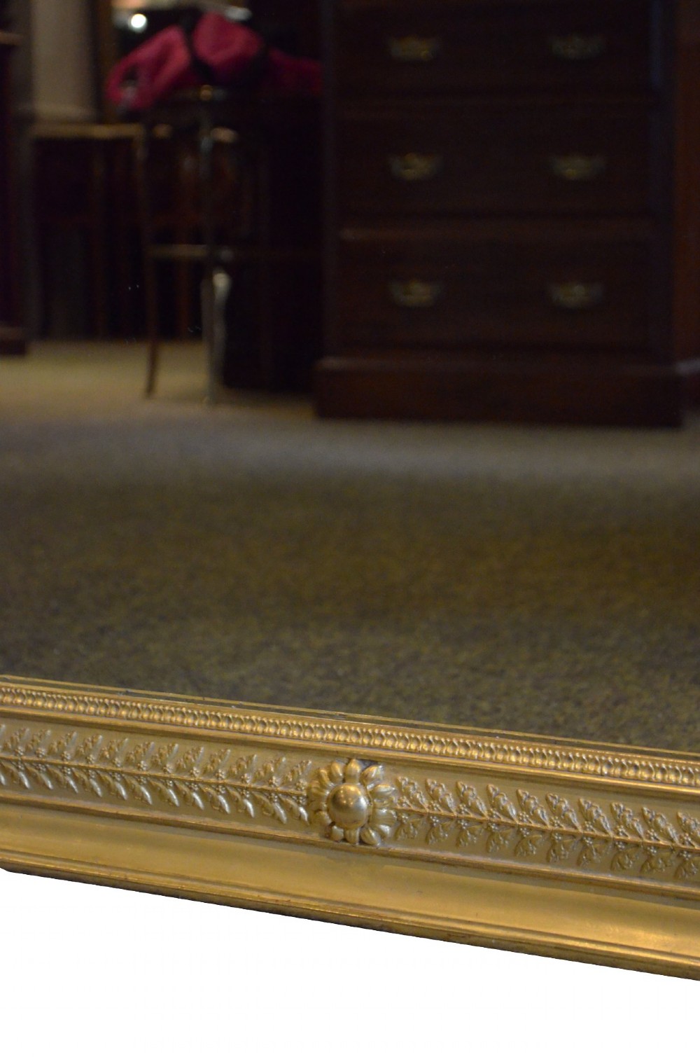 A large rectangular antique wall mirror featuring a carved giltwood frame decorated with detailed classical bead moulding and rosette bosses. View XII
