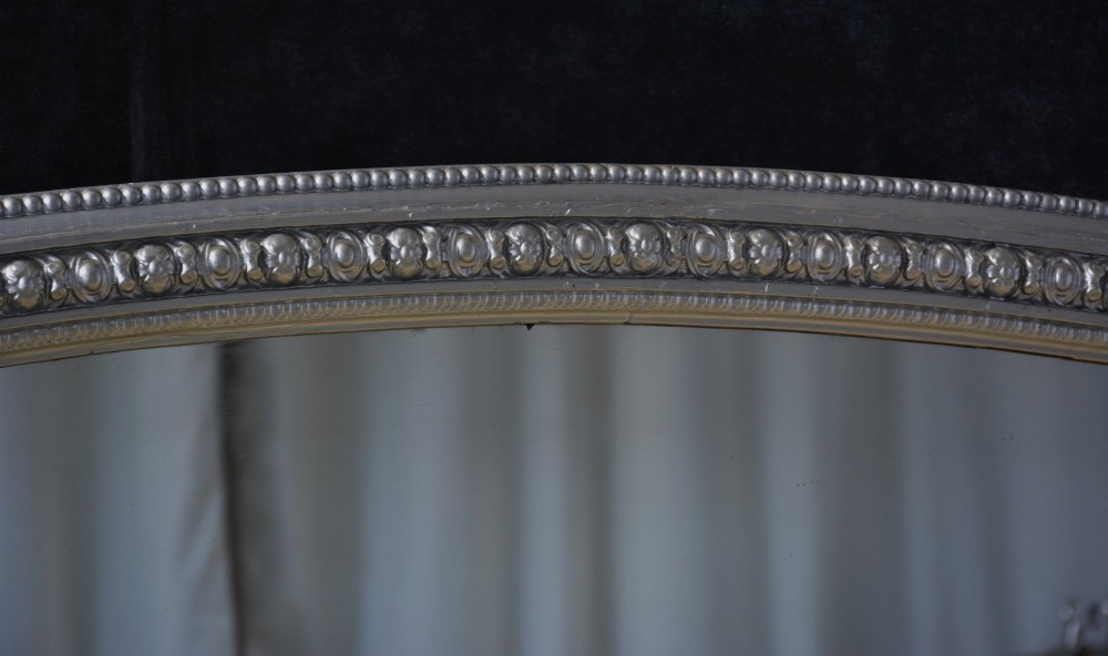 An arched Victorian silver-gilded overmantel mirror featuring beaded edge moulding along the frame. View II