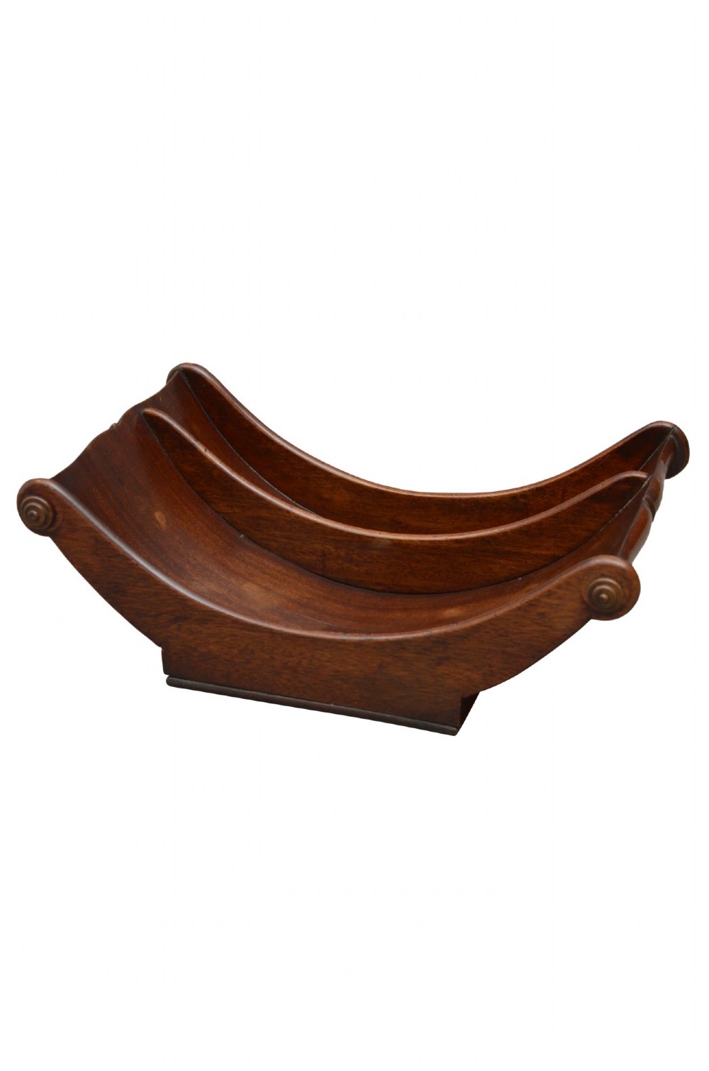 A Georgian mahogany cheese coaster displaying a crescent-shaped wooden body with carved scroll terminals and a central dividing partition.
