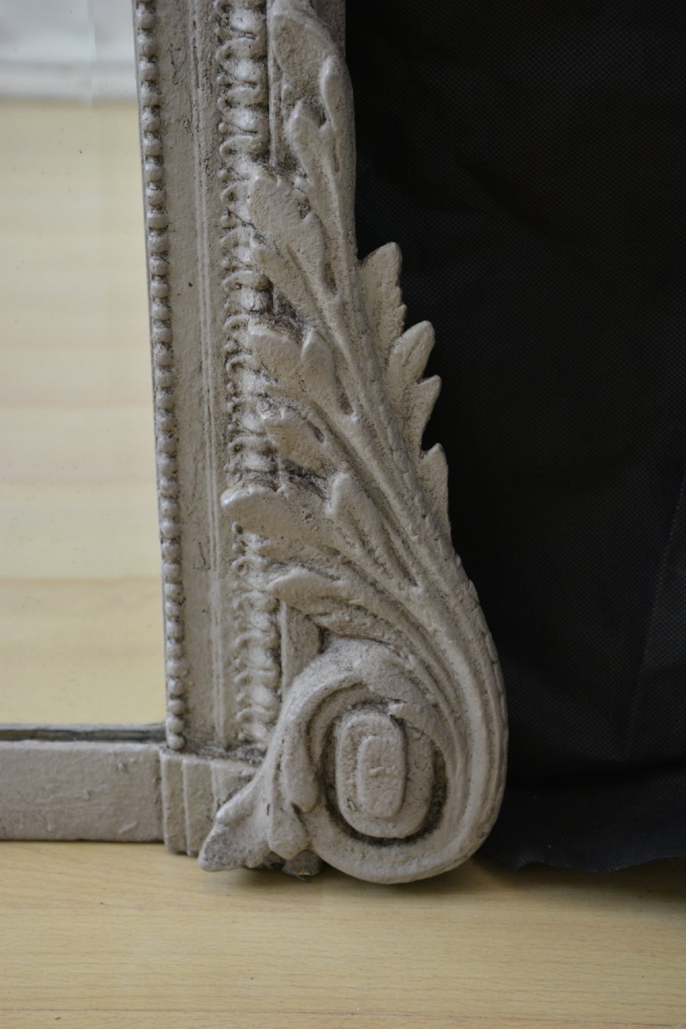 A tall grey-painted French Rococo style wall mirror featuring a carved ribbon top crest and scroll detailing. View V