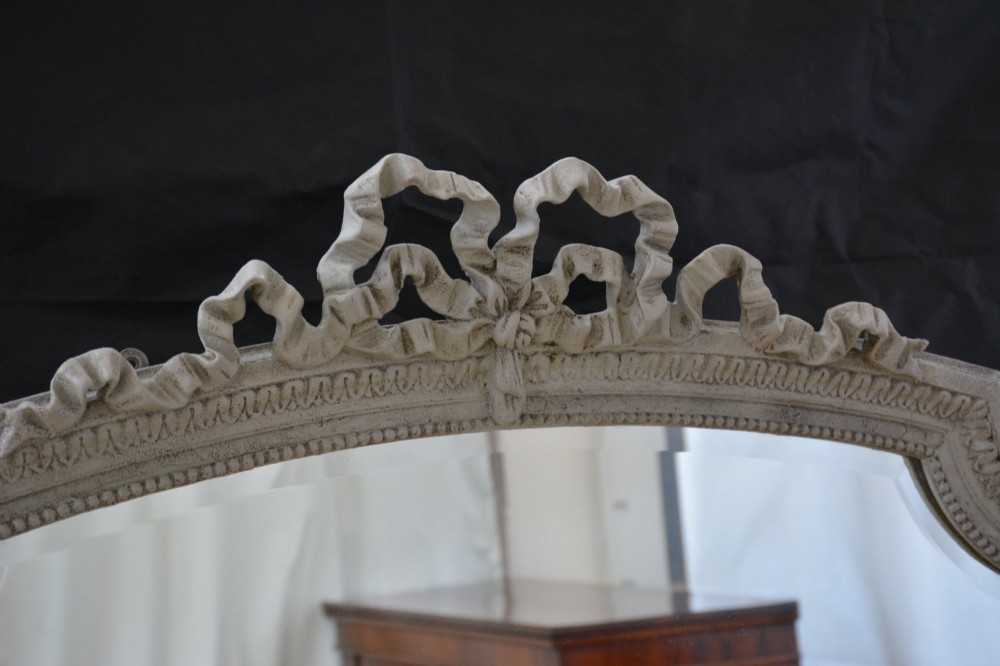 A tall grey-painted French Rococo style wall mirror featuring a carved ribbon top crest and scroll detailing. View XI