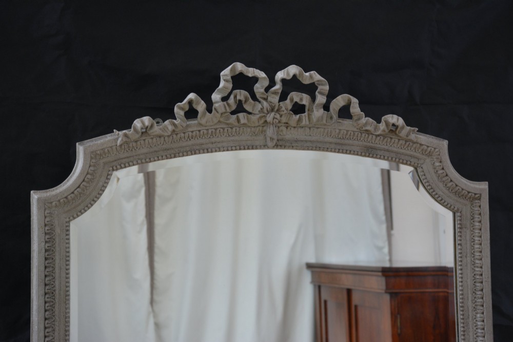 A tall grey-painted French Rococo style wall mirror featuring a carved ribbon top crest and scroll detailing. View XII