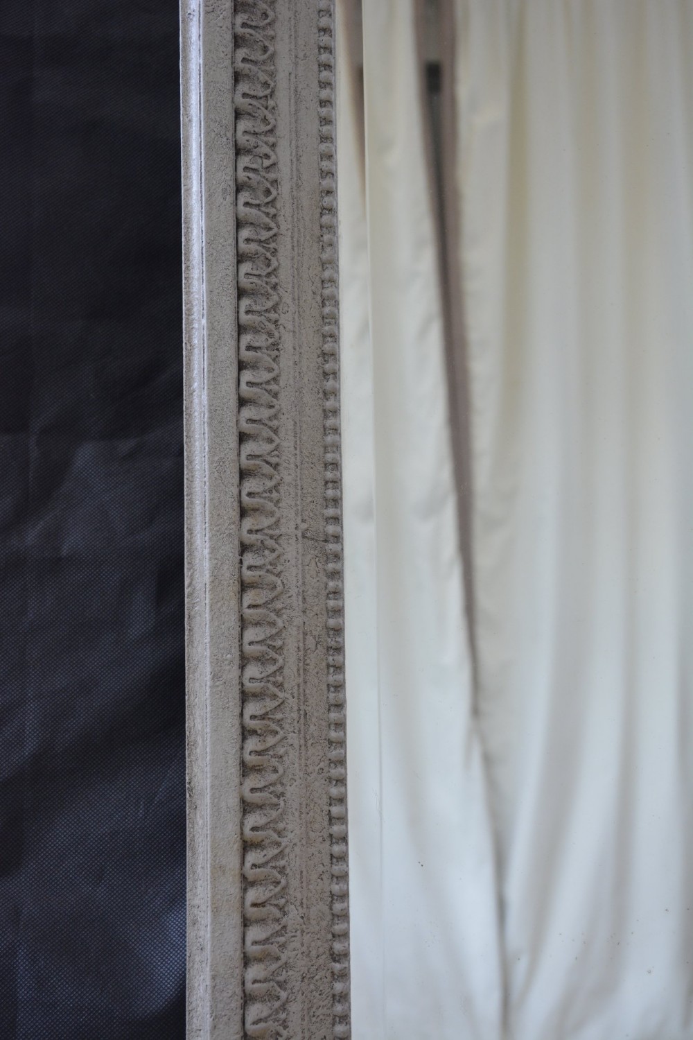 A tall grey-painted French Rococo style wall mirror featuring a carved ribbon top crest and scroll detailing. View XIII