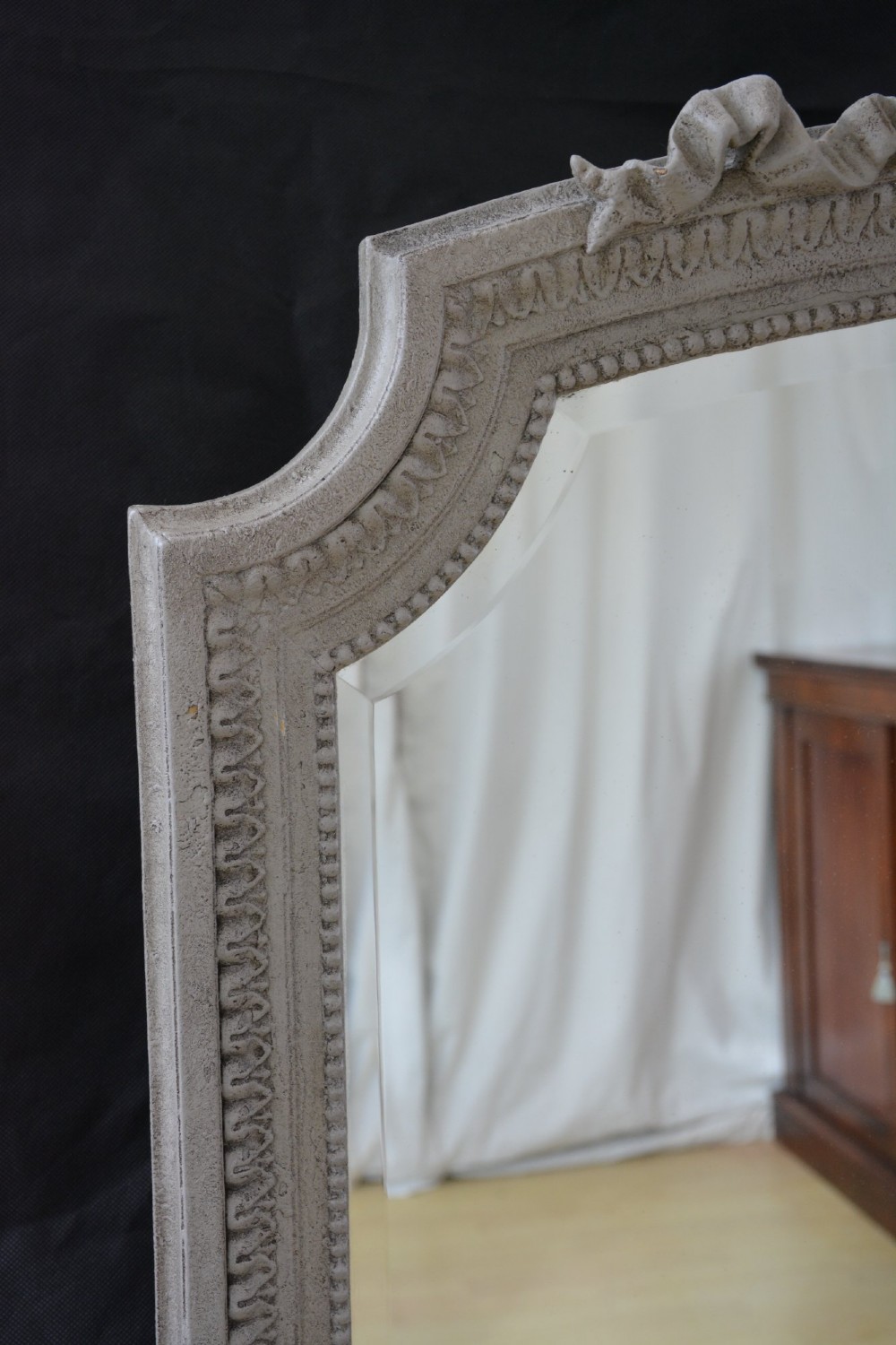 A tall grey-painted French Rococo style wall mirror featuring a carved ribbon top crest and scroll detailing. View XIV