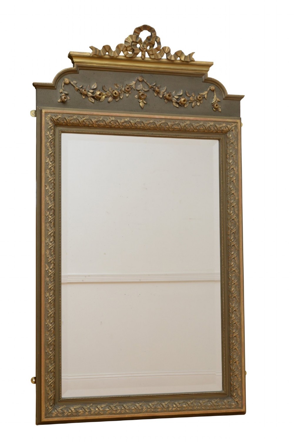 A tall antique French pier mirror featuring a gilded ribbon cresting, carved floral swags, and leaf moulding framing rectangular mirror glass. View IX