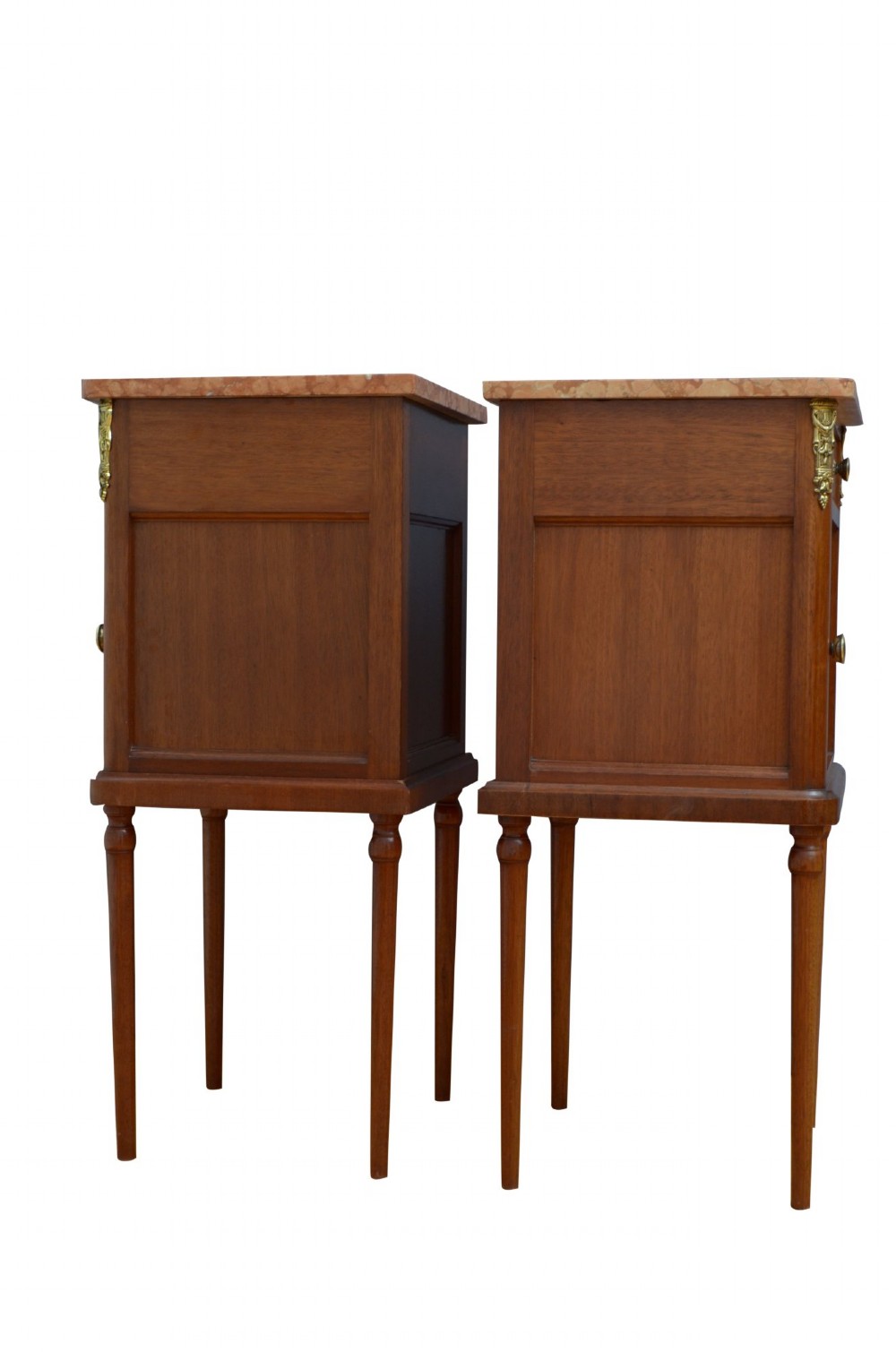 A pair of tall French Louis XVI style wooden bedside cabinets featuring pink marble tops, single drawers, cupboard doors with sunburst parquetry motifs, and slender turned legs. View V