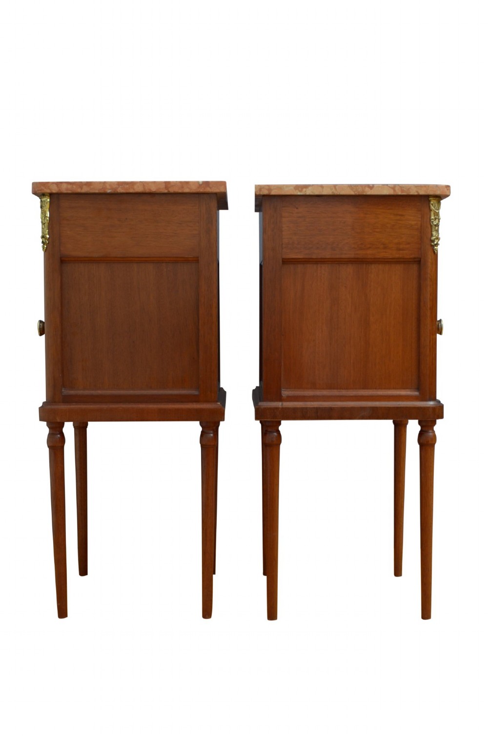 A pair of tall French Louis XVI style wooden bedside cabinets featuring pink marble tops, single drawers, cupboard doors with sunburst parquetry motifs, and slender turned legs. View VII