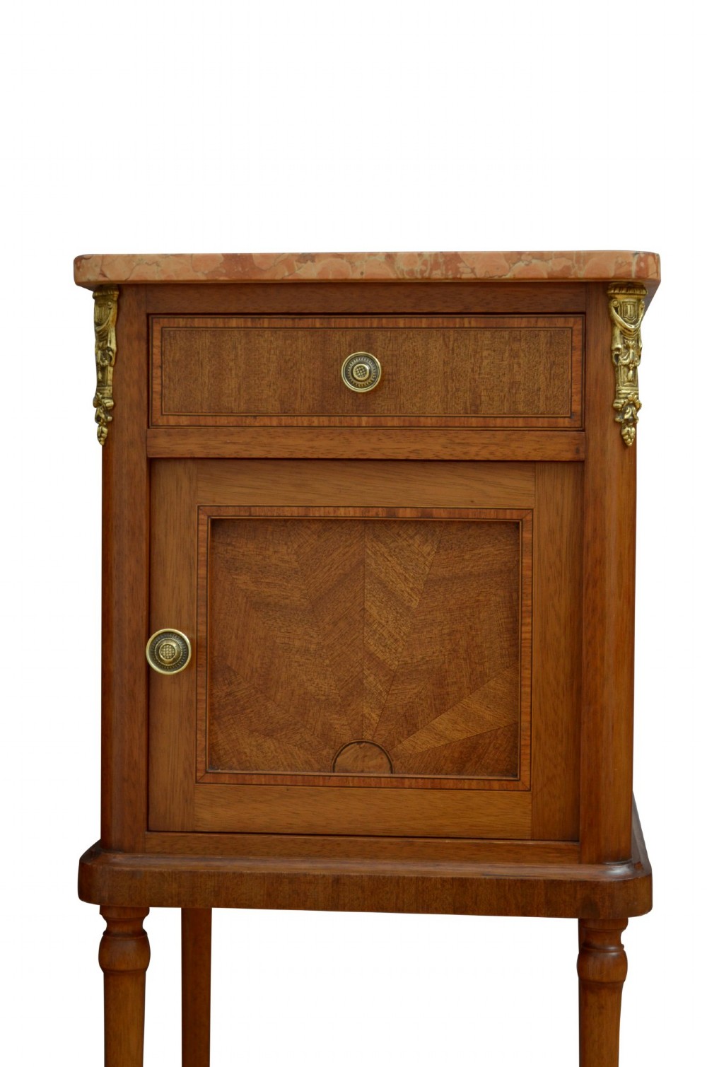 A pair of tall French Louis XVI style wooden bedside cabinets featuring pink marble tops, single drawers, cupboard doors with sunburst parquetry motifs, and slender turned legs. View XII