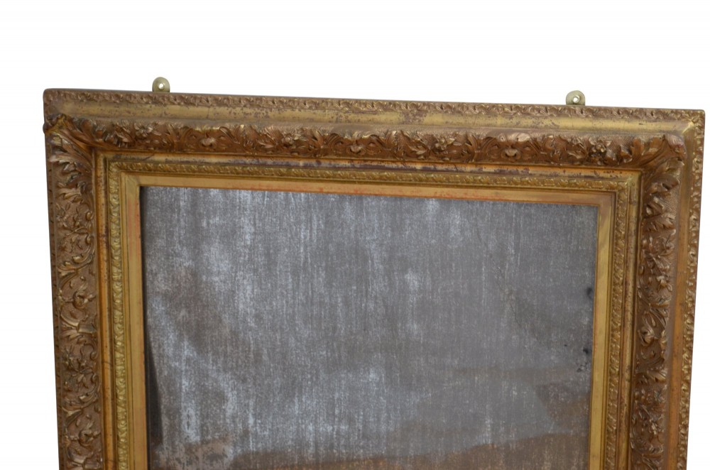 A rectangular antique Rococo giltwood wall mirror featuring carved acanthus foliage mouldings around a heavily foxed mirror glass pane. View V