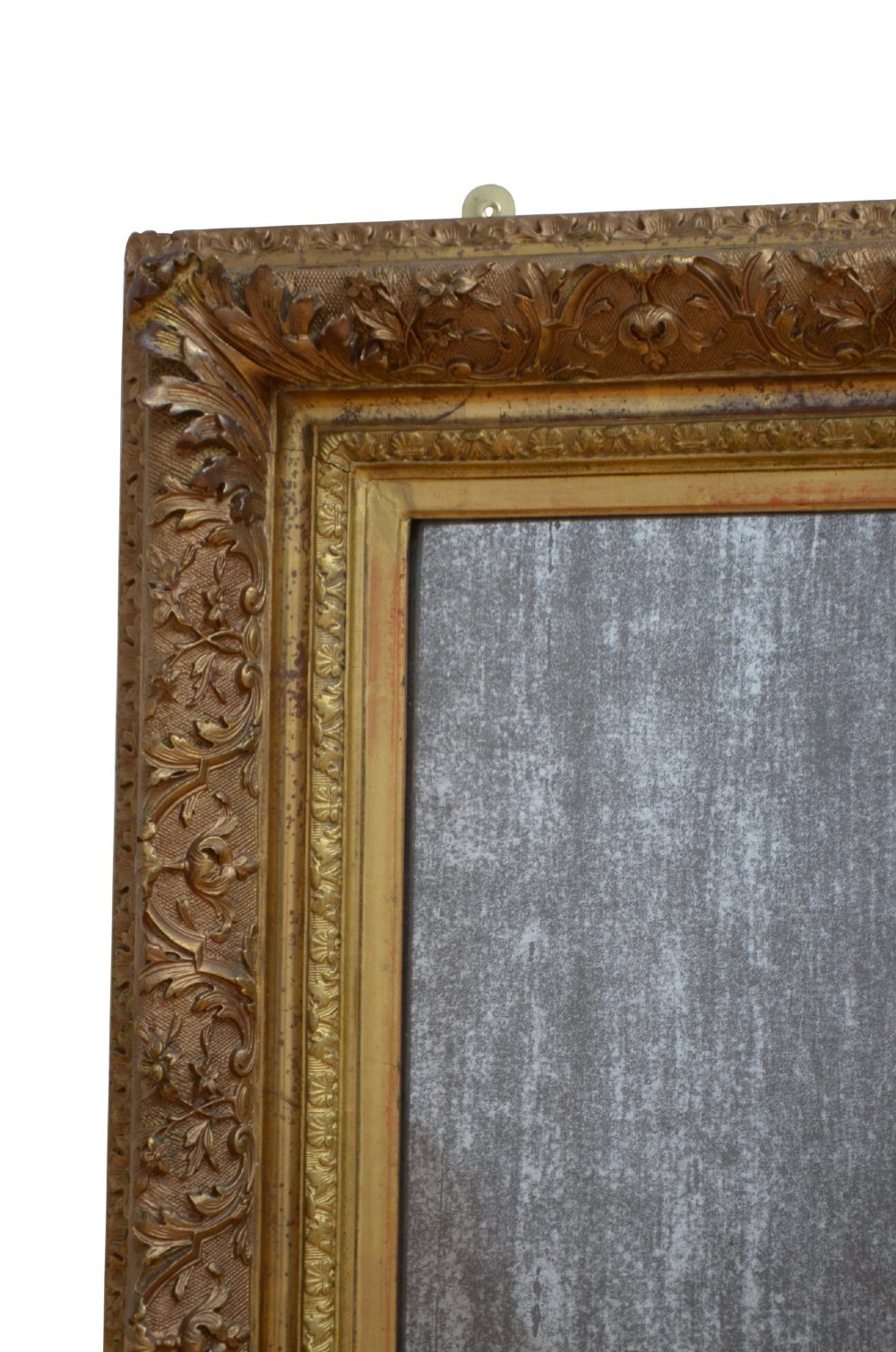 A rectangular antique Rococo giltwood wall mirror featuring carved acanthus foliage mouldings around a heavily foxed mirror glass pane. View IX