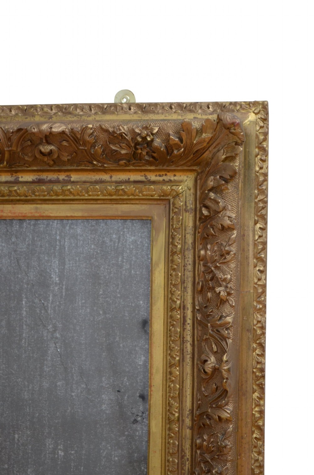 A rectangular antique Rococo giltwood wall mirror featuring carved acanthus foliage mouldings around a heavily foxed mirror glass pane. View X
