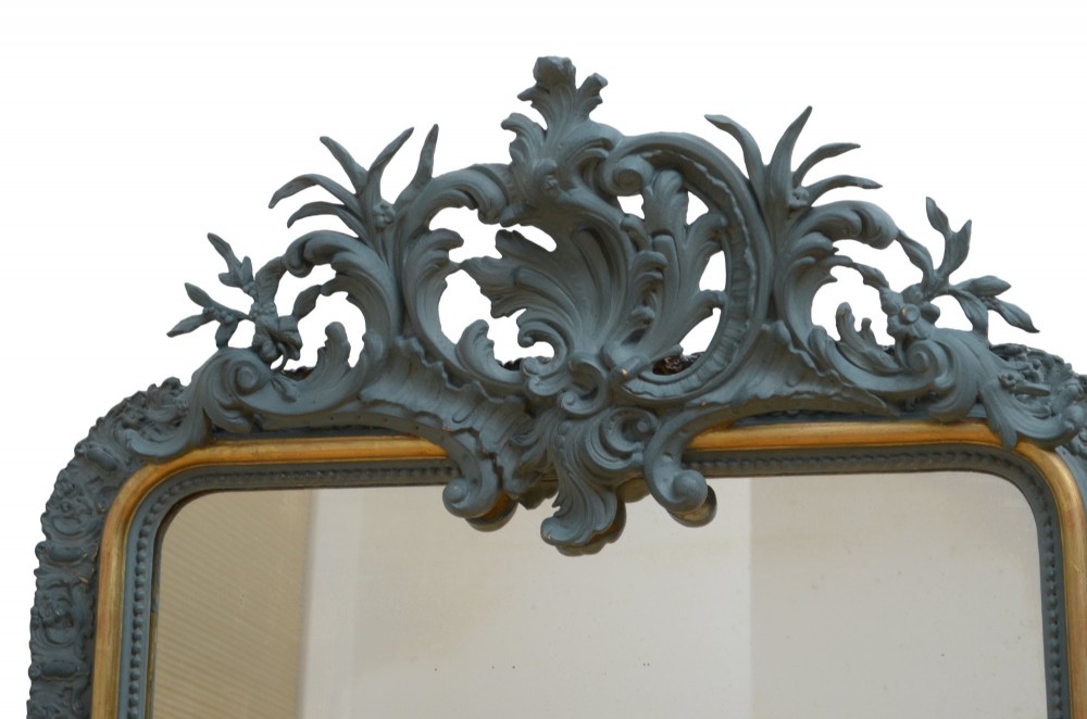 A tall rectangular wall mirror featuring a dark grey carved frame with a golden inner bead and an intricate foliage crest at the top. View IX