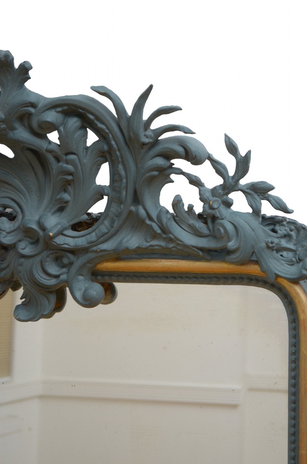 A tall rectangular wall mirror featuring a dark grey carved frame with a golden inner bead and an intricate foliage crest at the top. View XII