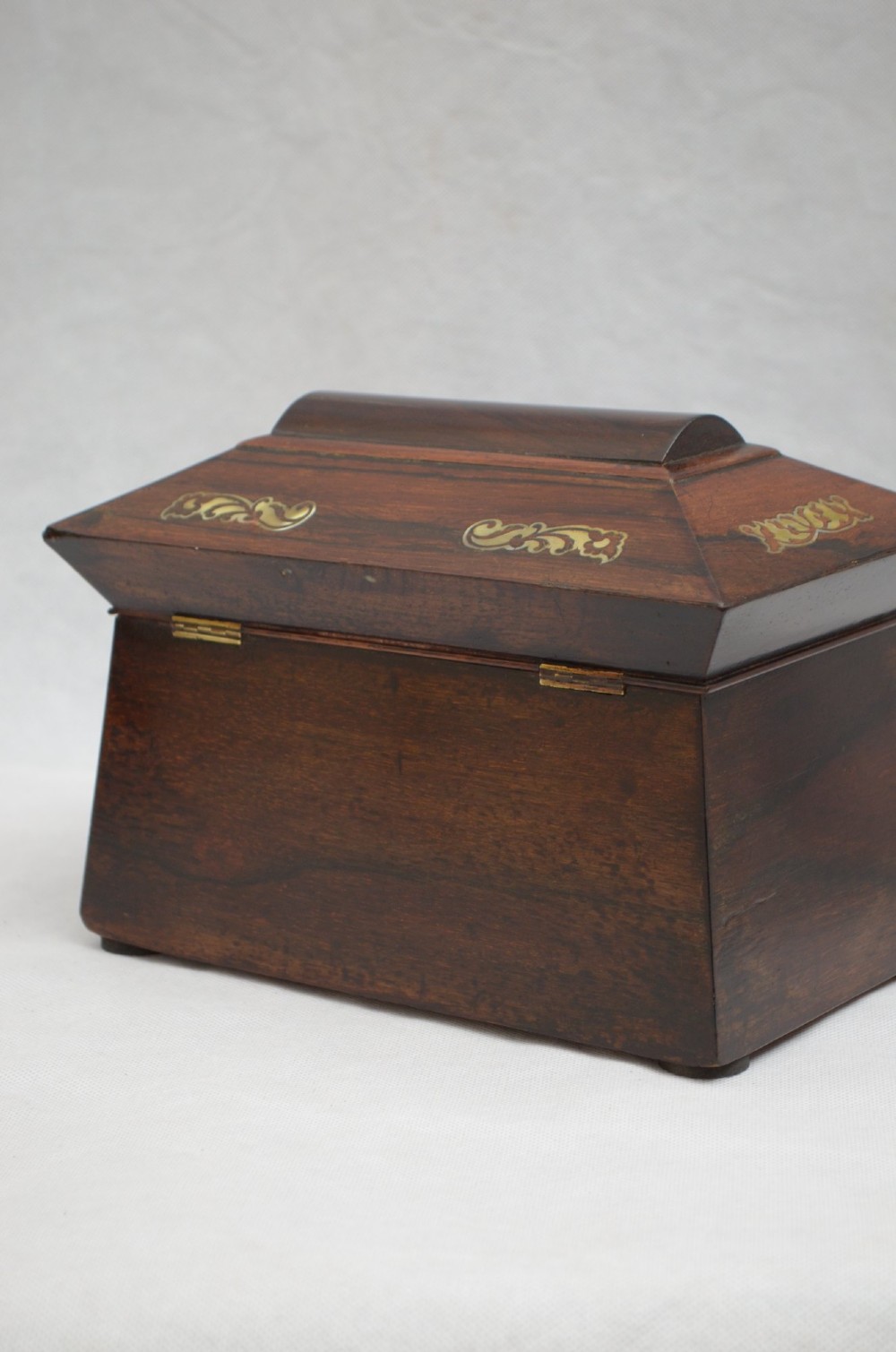 A Regency period rosewood tea caddy in a sarcophagus shape with mother-of-pearl floral scroll inlay and a brass keyhole. View VII