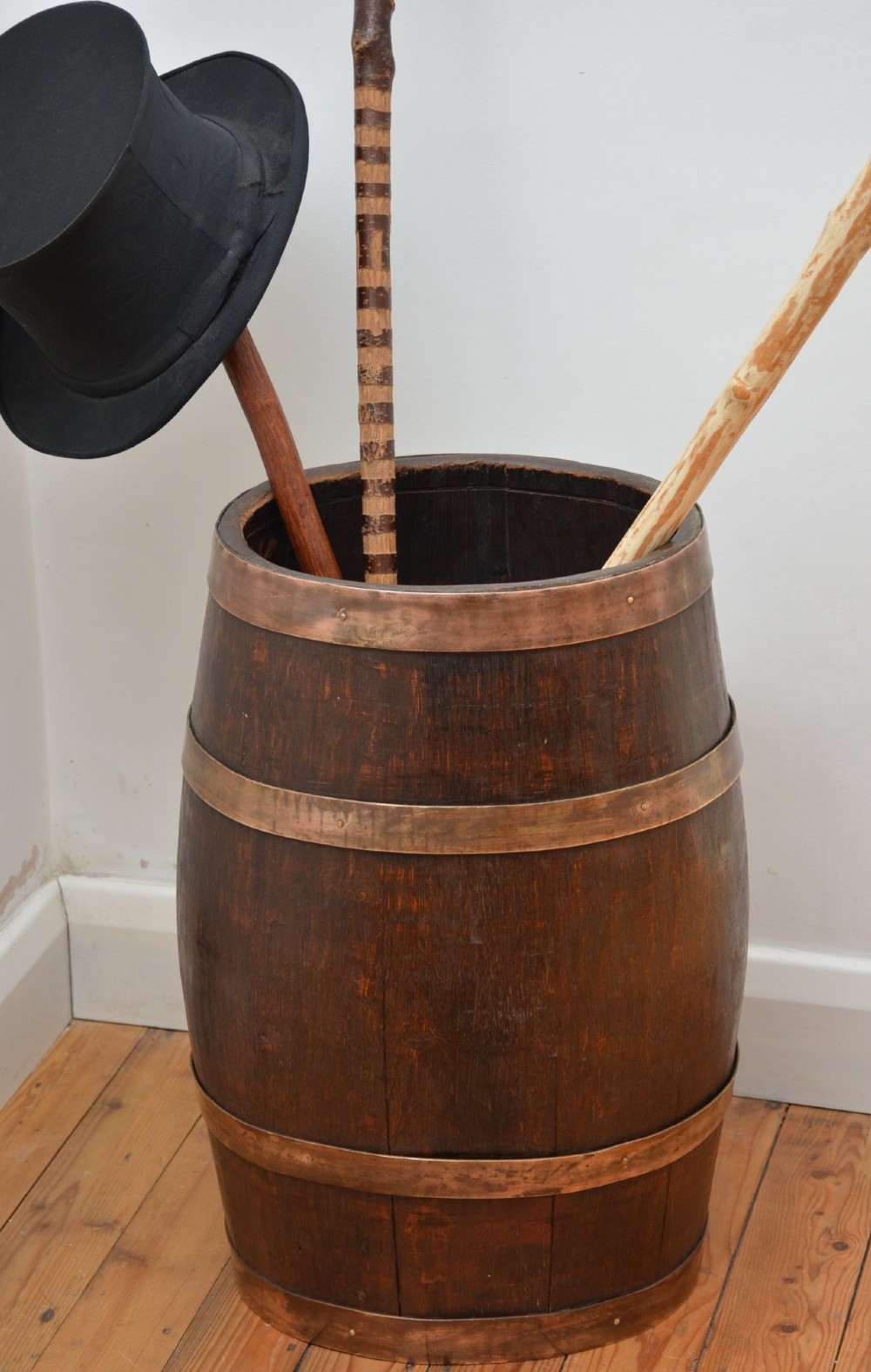 A Victorian dark oak coopered barrel umbrella stand with polished metal binding hoops.