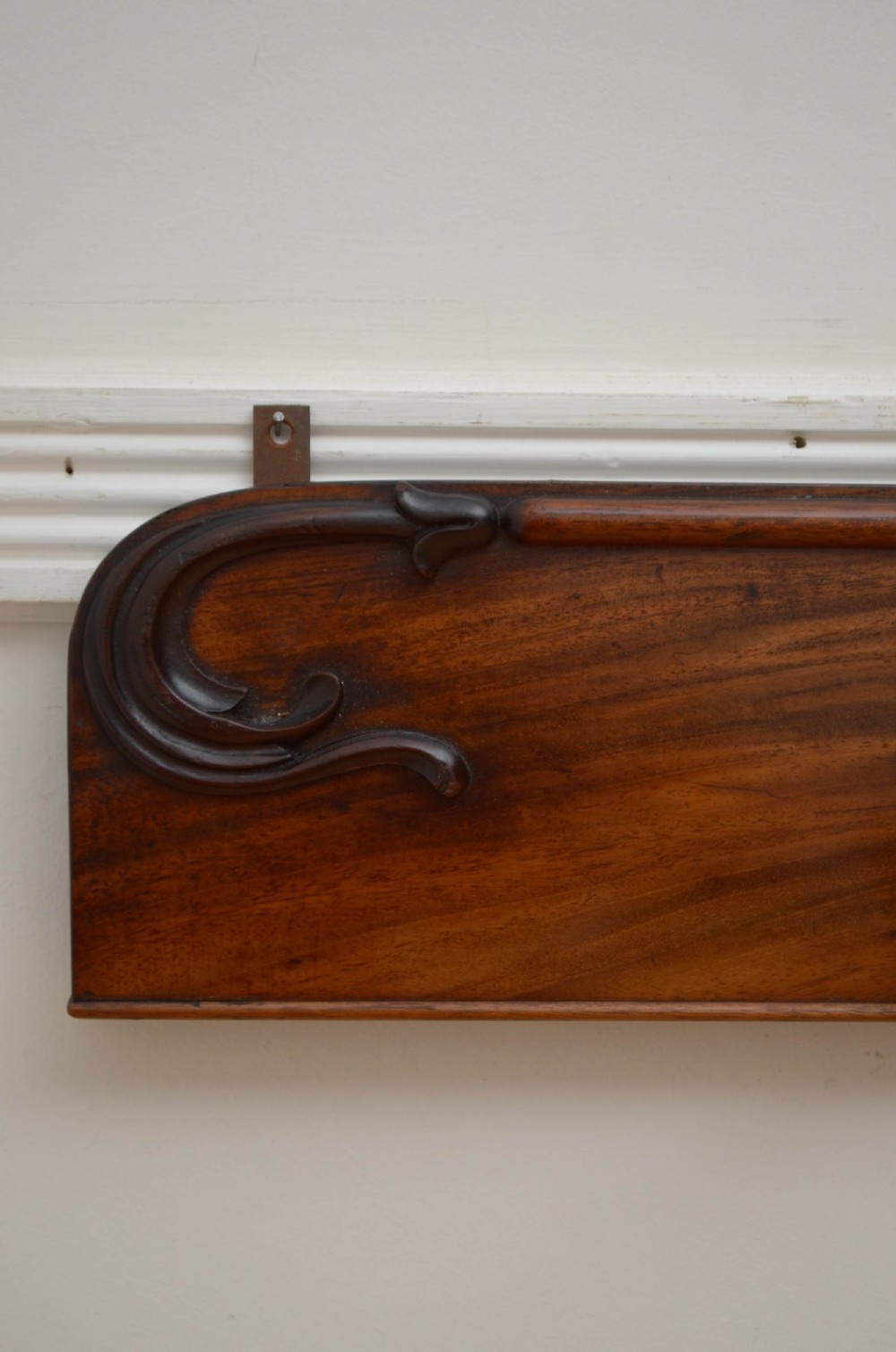 An antique wall-mounted mahogany coat rack featuring five rope-twist brass hooks topped with white ceramic knobs and carved scrollwork details. View VI