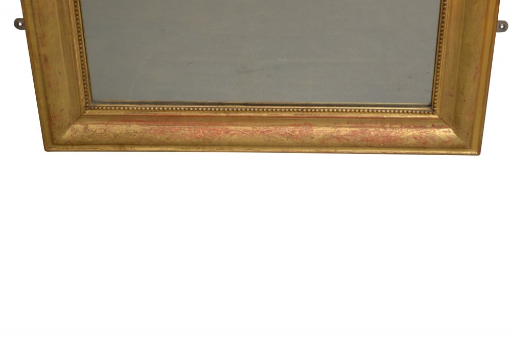 A tall arched giltwood wall mirror featuring an intricate shell cresting at the top and floral carved motifs along the gilded frame. View IV