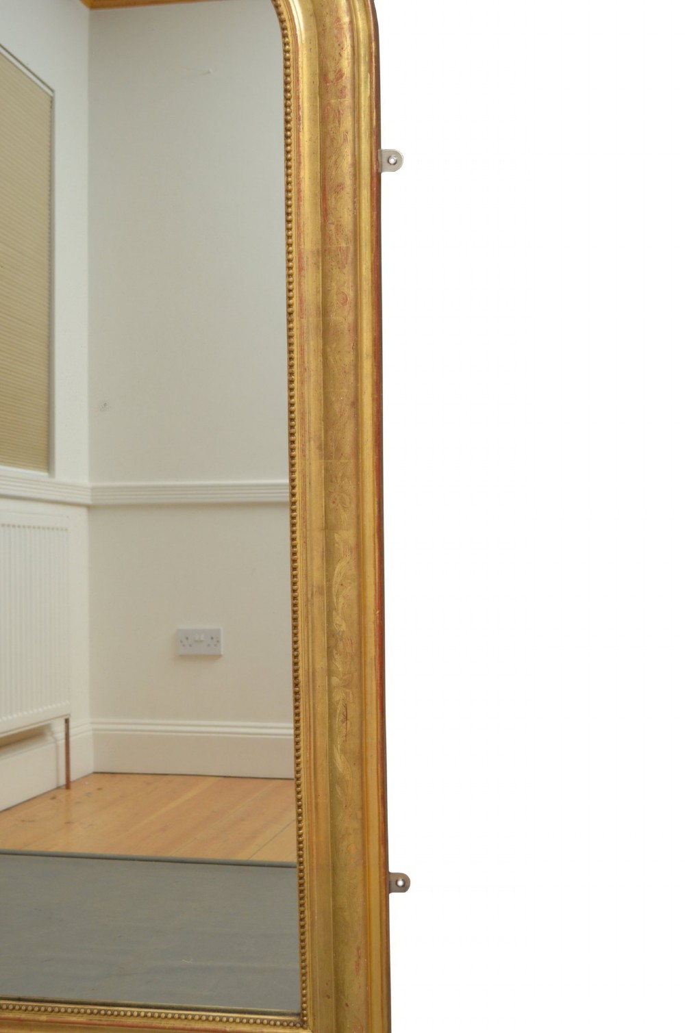 A tall arched giltwood wall mirror featuring an intricate shell cresting at the top and floral carved motifs along the gilded frame. View XI