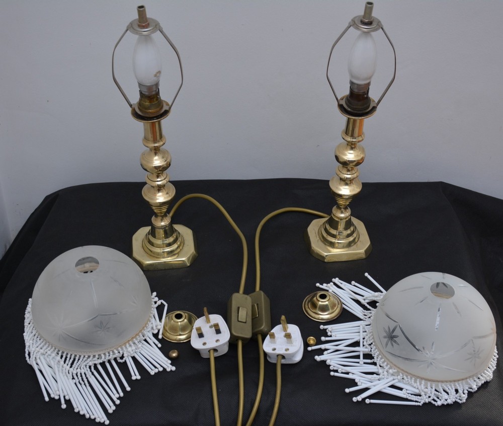 A pair of illuminated Victorian turned brass table lamps featuring etched frosted glass dome shades with beaded fringe hanging around the rim. View II