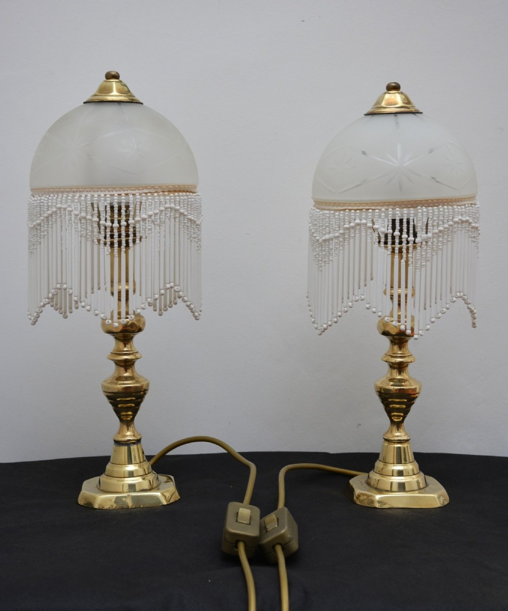 A pair of illuminated Victorian turned brass table lamps featuring etched frosted glass dome shades with beaded fringe hanging around the rim. View XIII