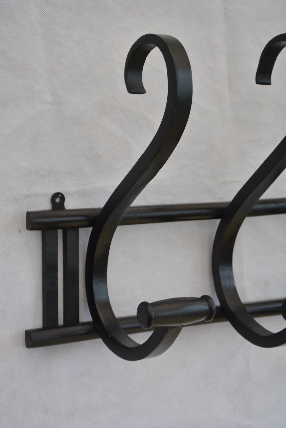An ebonised bentwood wall-mounted coat rack featuring four large S-curved hooks mounted on a horizontal wooden backing rail. View IV