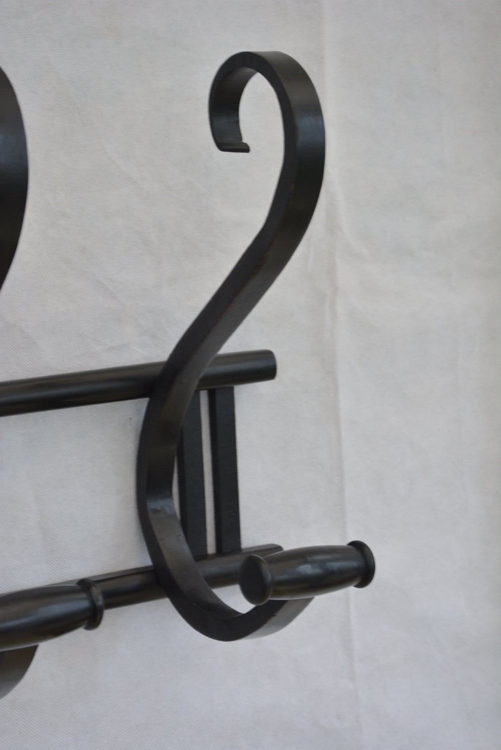 An ebonised bentwood wall-mounted coat rack featuring four large S-curved hooks mounted on a horizontal wooden backing rail. View VII