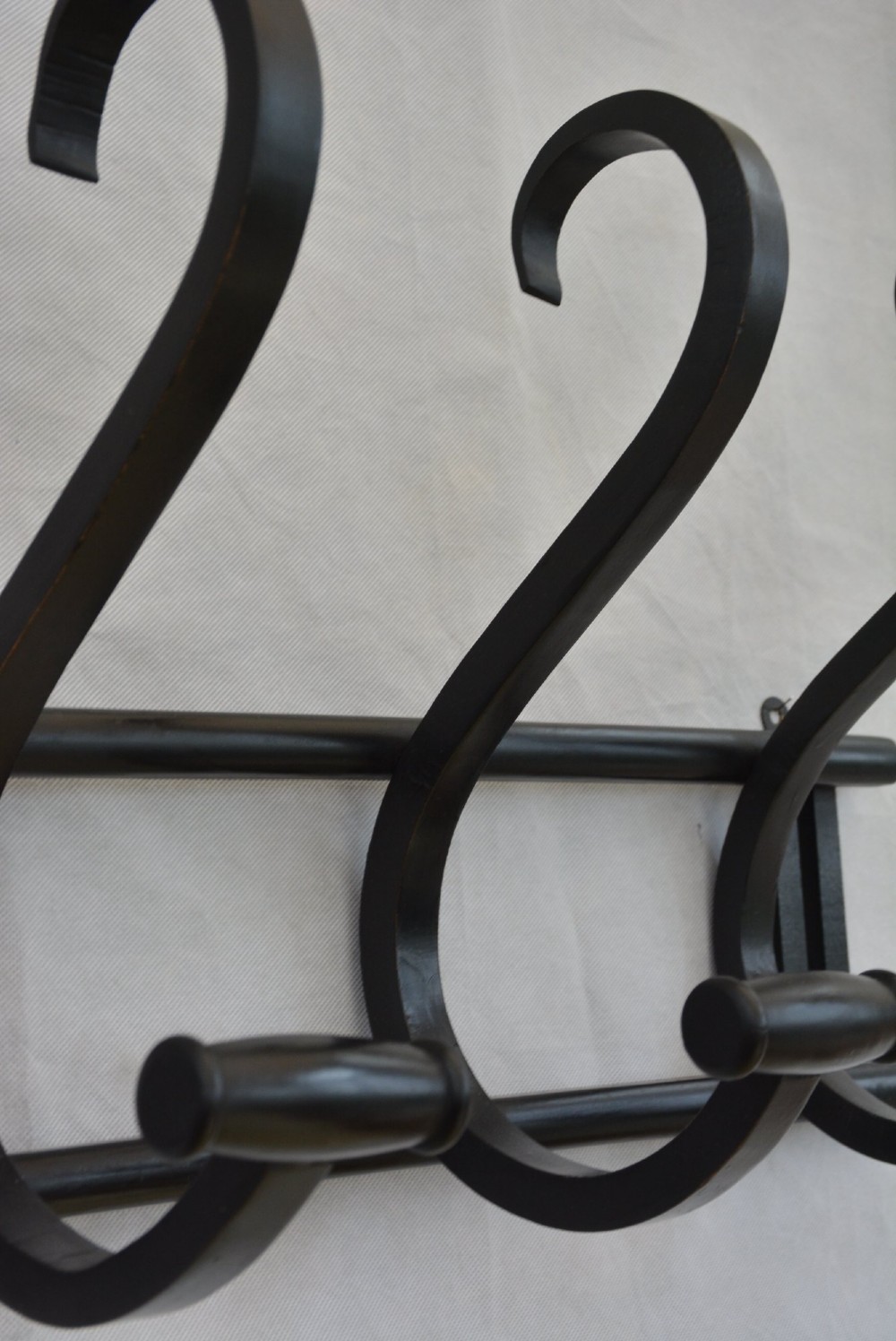 An ebonised bentwood wall-mounted coat rack featuring four large S-curved hooks mounted on a horizontal wooden backing rail. View XI