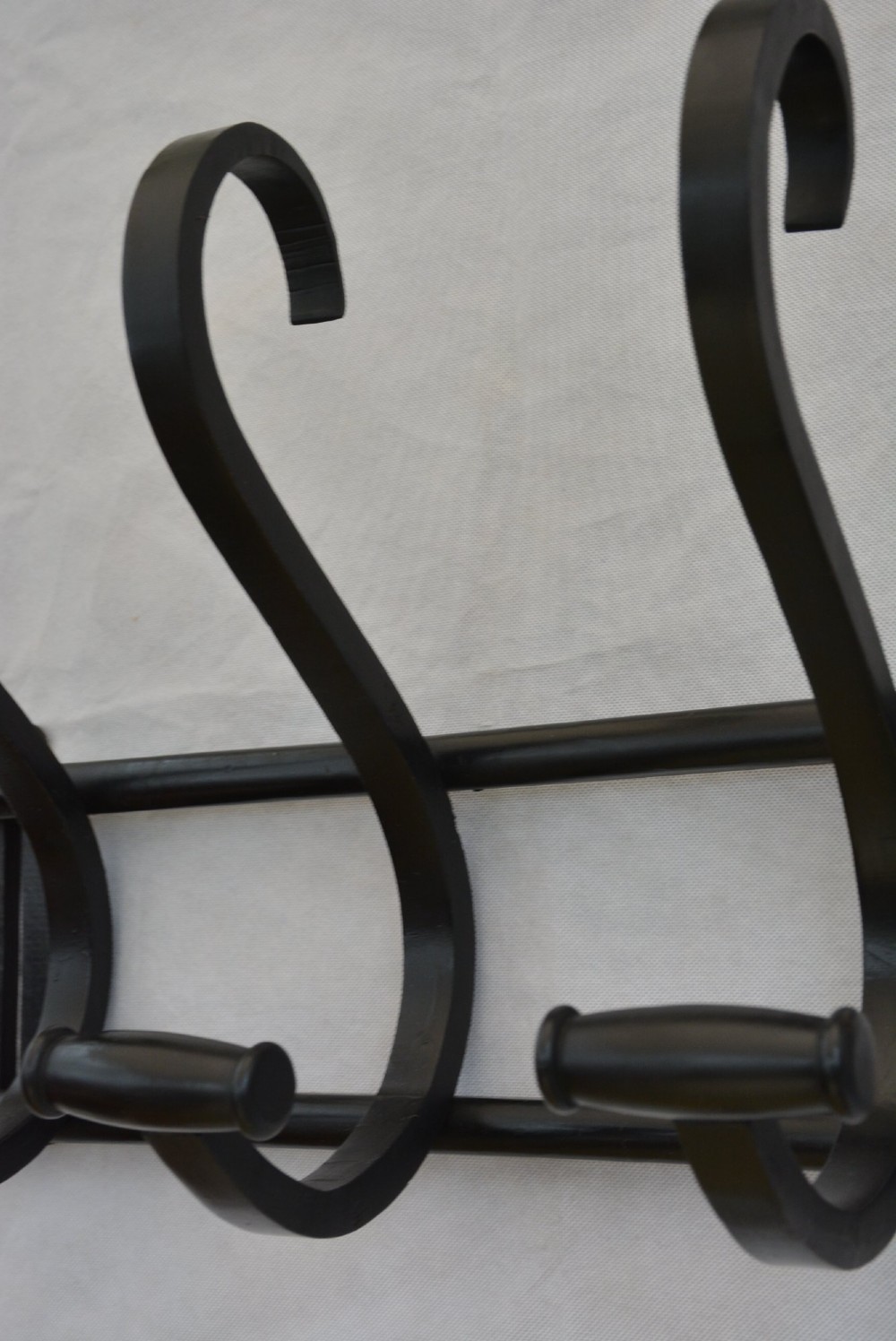 An ebonised bentwood wall-mounted coat rack featuring four large S-curved hooks mounted on a horizontal wooden backing rail. View XIII