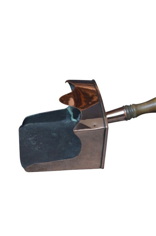 A copper coal helmet scuttle with a fixed overhead swing handle, riveted construction, and an integrated shovel with a turned wooden handle. View V