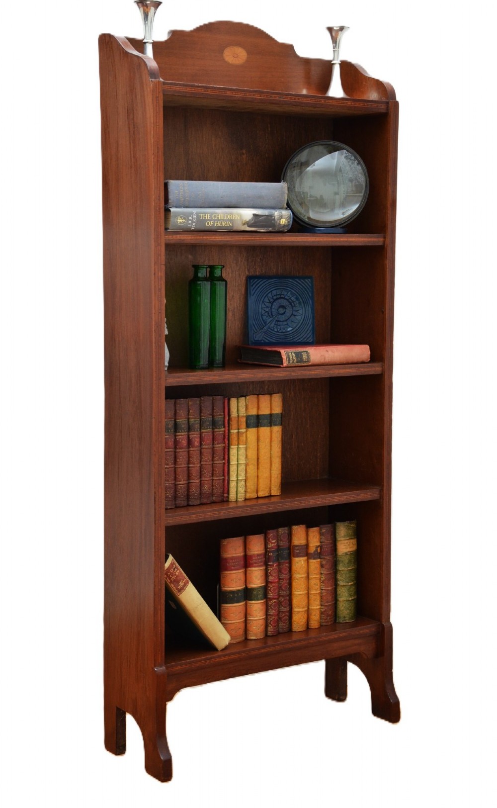 A slim Edwardian mahogany open bookcase featuring four shelves, an inlaid oval motif on the shaped gallery top, and bracket feet. View XIII