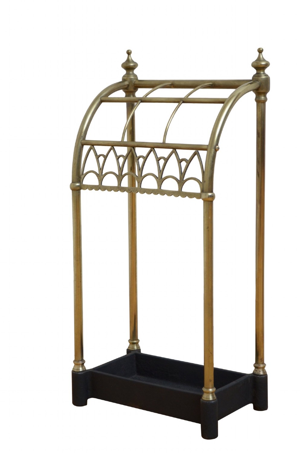A Victorian tubular brass umbrella stand featuring a curved upper section with internal divisions, finial caps, a arched fretwork apron, and a black cast iron drip tray base. View III