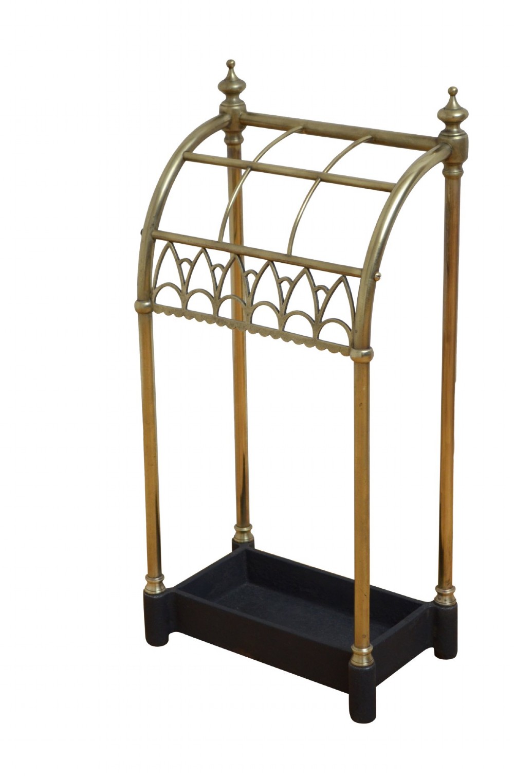 A Victorian tubular brass umbrella stand featuring a curved upper section with internal divisions, finial caps, a arched fretwork apron, and a black cast iron drip tray base.