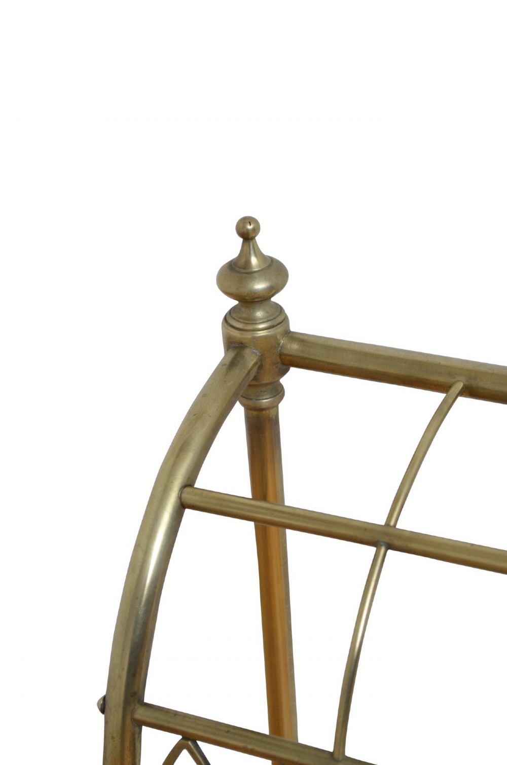 A Victorian tubular brass umbrella stand featuring a curved upper section with internal divisions, finial caps, a arched fretwork apron, and a black cast iron drip tray base. View V