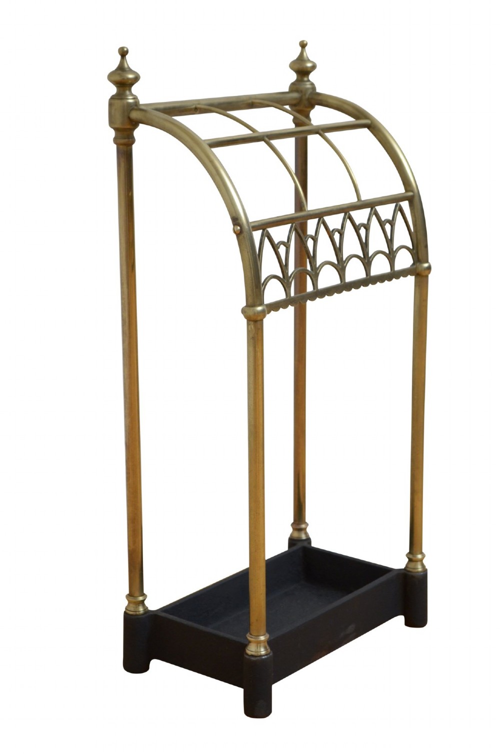 A Victorian tubular brass umbrella stand featuring a curved upper section with internal divisions, finial caps, a arched fretwork apron, and a black cast iron drip tray base. View VIII