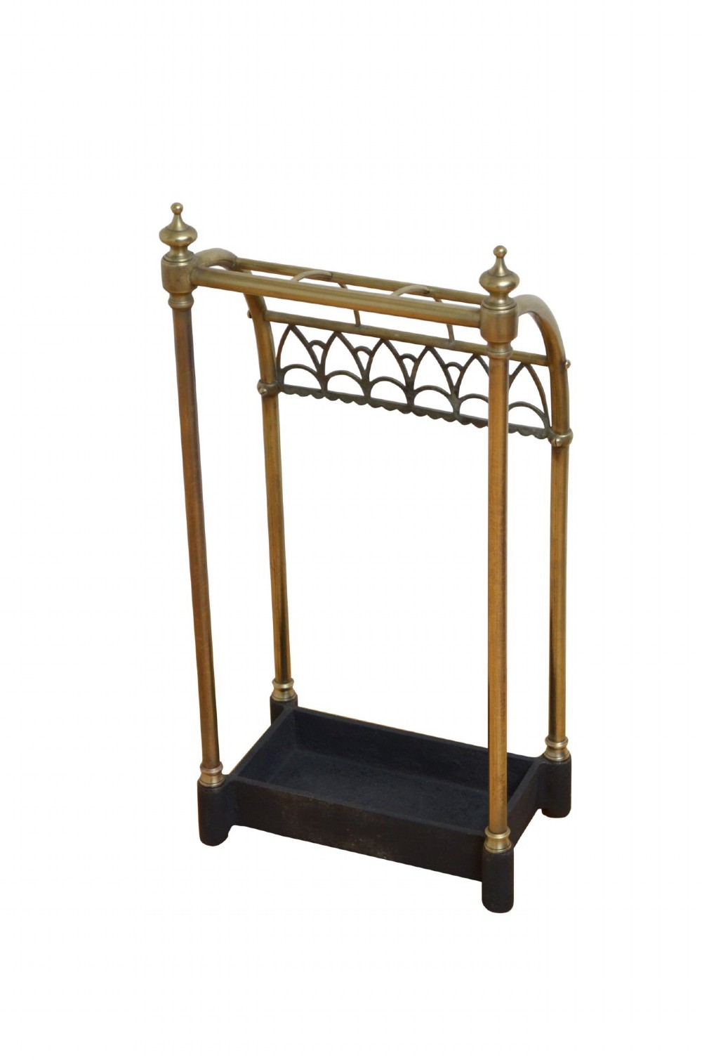 A Victorian tubular brass umbrella stand featuring a curved upper section with internal divisions, finial caps, a arched fretwork apron, and a black cast iron drip tray base. View IX