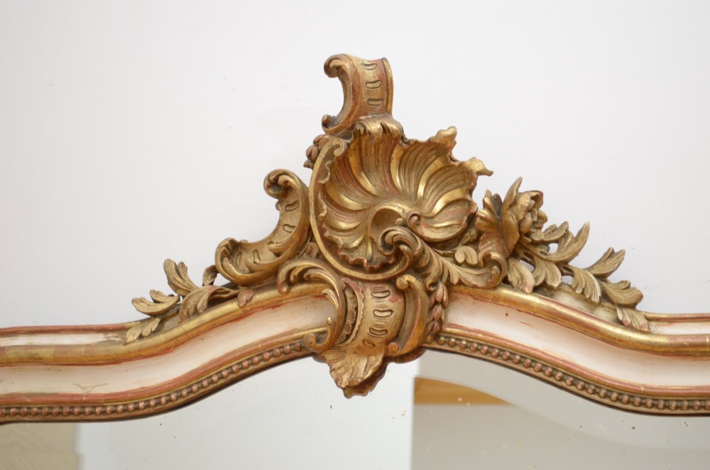 An arched French Chateau style wall mirror featuring a gilded wooden frame topped with a decorative carved shell crest. View VII