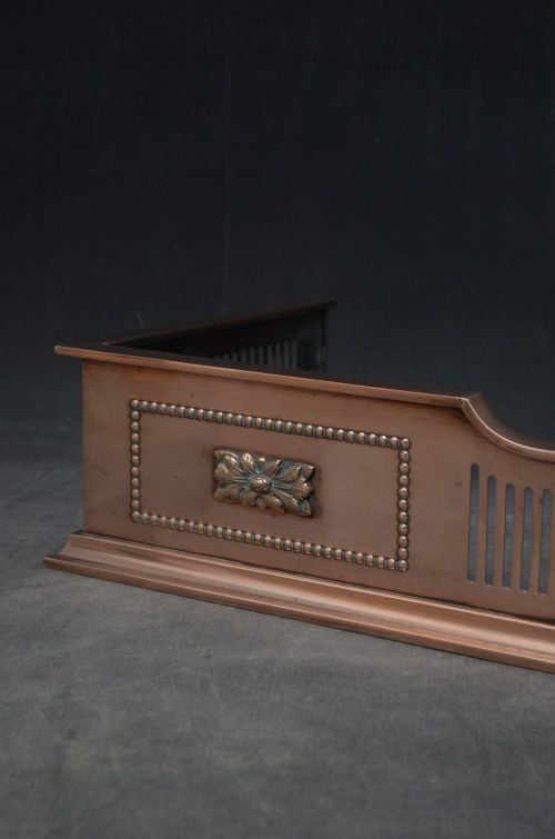 An antique Victorian copper fireplace fender featuring pierced vertical slots and side panels embellished with raised floral paterae and beaded edging. View VIII